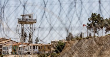A U.N. outpost is seen inside the buffer zone with the flags of Türkiye and the Turkish Republic of Northern Cyprus visible on the right, Lefkoşa, Jul. 20, 2024. (Reuters File Photo)