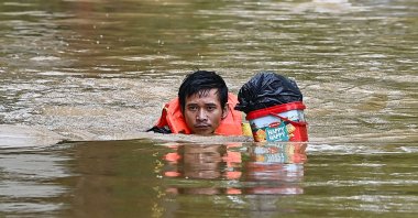 A man swims with belongings through a flooded street in Hanoi, Vietnam, Sept. 10, 2024. (AFP Photo)