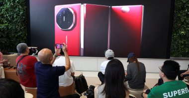 People watch the launch event of Huawei’s new Mate XT, a three-way foldable smartphone, live-streamed at a Huawei flagship store, Beijing, China, Sept. 10, 2024. (Reuters Photo)