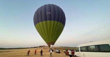 People taking photos of a hot air balloon while others board the balloon for a ride, Göbeklitepe, Şanlıurfa, Türkiye, Sept. 8, 2024. (AA Photo)