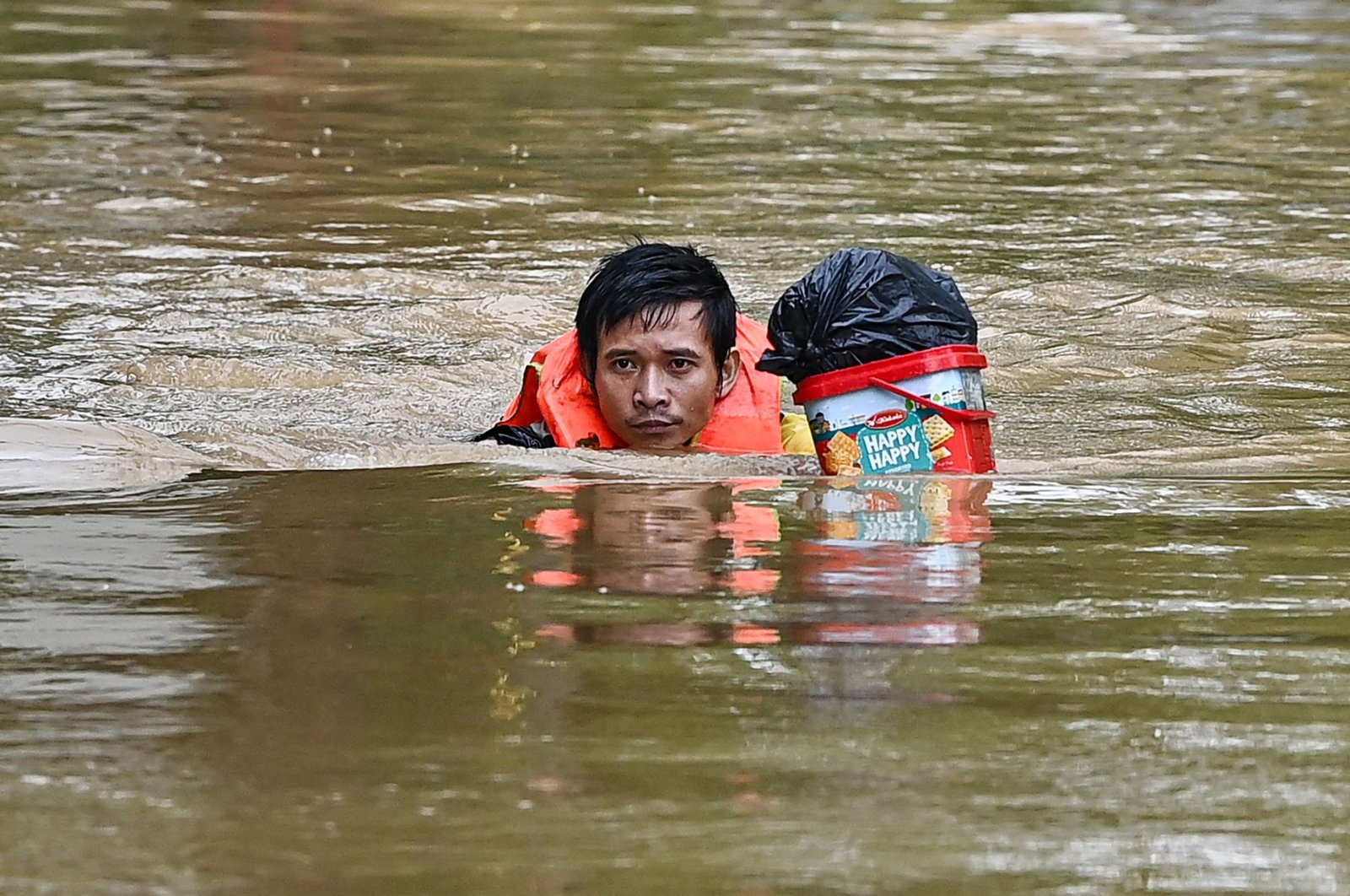 A man swims with belongings through a flooded street in Hanoi, Vietnam, Sept. 10, 2024. (AFP Photo)