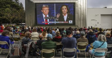 People gather outside the Berkeley Art Museum and Pacific Film Archive to watch the presidential debate, in Berkeley, California, Sept. 10, 2024. (AP Photo)