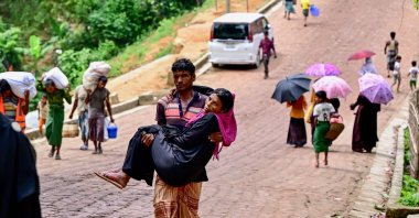 A man carrying his sick mother returns from a field hospital facility at a Rohingya refugee camp in Ukhia, Bangladesh, Sept. 10, 2024. (AFP Photo)