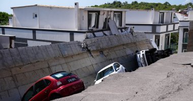 Two cars and a truck are trapped beneath a collapsed wall in Izmir, Türkiye, Sept. 11, 2024. (AA Photo)