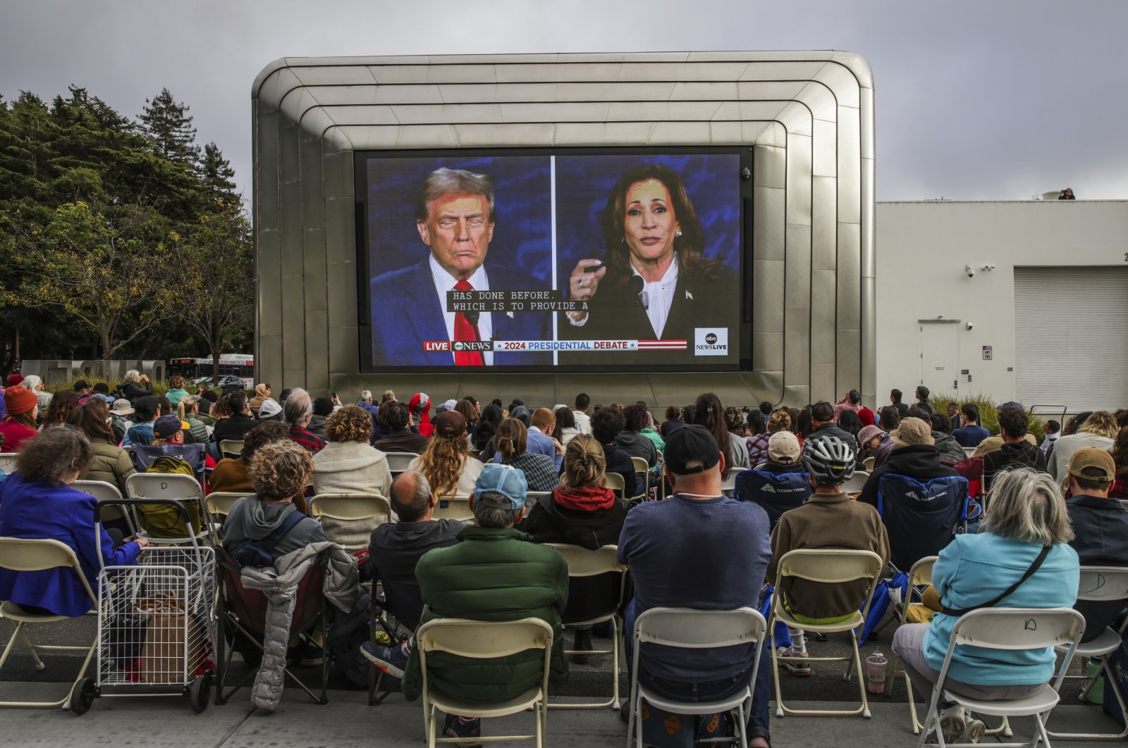 People gather outside the Berkeley Art Museum and Pacific Film Archive to watch the presidential debate, in Berkeley, California, Sept. 10, 2024. (AP Photo)