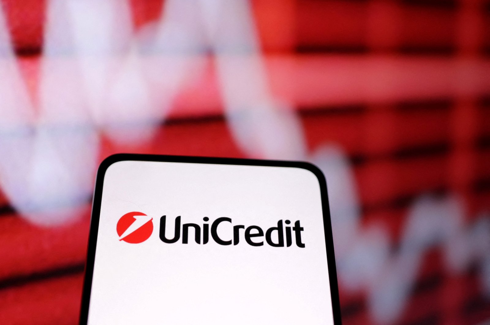 UniCredit bank logo and a decreasing stock graph are seen in this illustration taken March 12, 2023. (Reuters Photo)