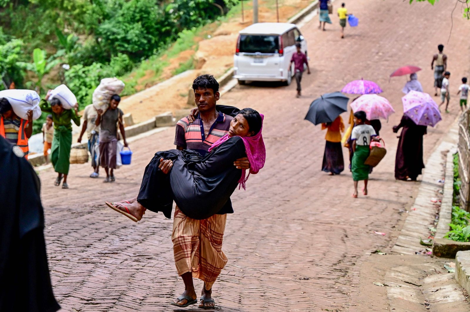 A man carrying his sick mother returns from a field hospital facility at a Rohingya refugee camp in Ukhia, Bangladesh, Sept. 10, 2024. (AFP Photo)