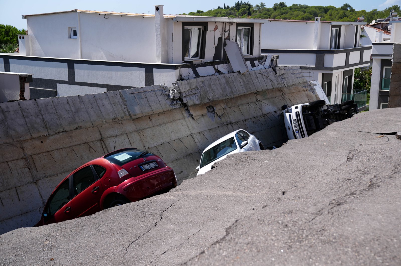 Two cars and a truck are trapped beneath a collapsed wall in Izmir, Türkiye, Sept. 11, 2024. (AA Photo)