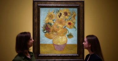 Visitors look at the painting  &quot;Sunflowers&quot; made by late Dutch artist Vincent Van Gogh in 1889, during a press preview for &quot;Van Gogh: Poets and Lovers&quot; exhibition at the National Gallery, London, U.K., Sept. 9, 2024. (AFP Photo)