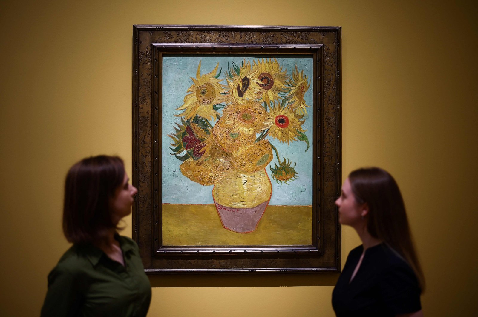 Visitors look at the painting  &quot;Sunflowers&quot; made by late Dutch artist Vincent Van Gogh in 1889, during a press preview for &quot;Van Gogh: Poets and Lovers&quot; exhibition at the National Gallery, London, U.K., Sept. 9, 2024. (AFP Photo)