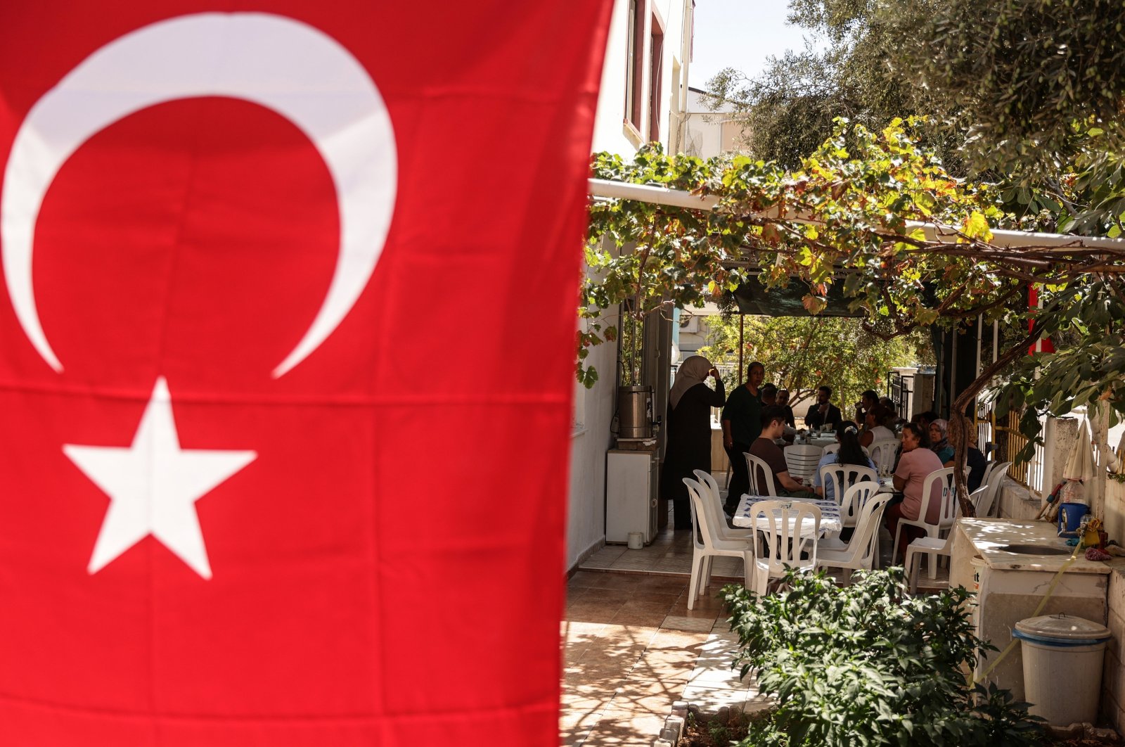 Relatives of Turkish American activist Ayşenur Ezgi Eygi, who was shot dead in the West Bank, sit in her grandfather&#039;s garden decorated with Turkish flags during a gathering to mourn her death, in the Didim district of Aydın, Türkiye, Sept. 11, 2024. (EPA Photo)