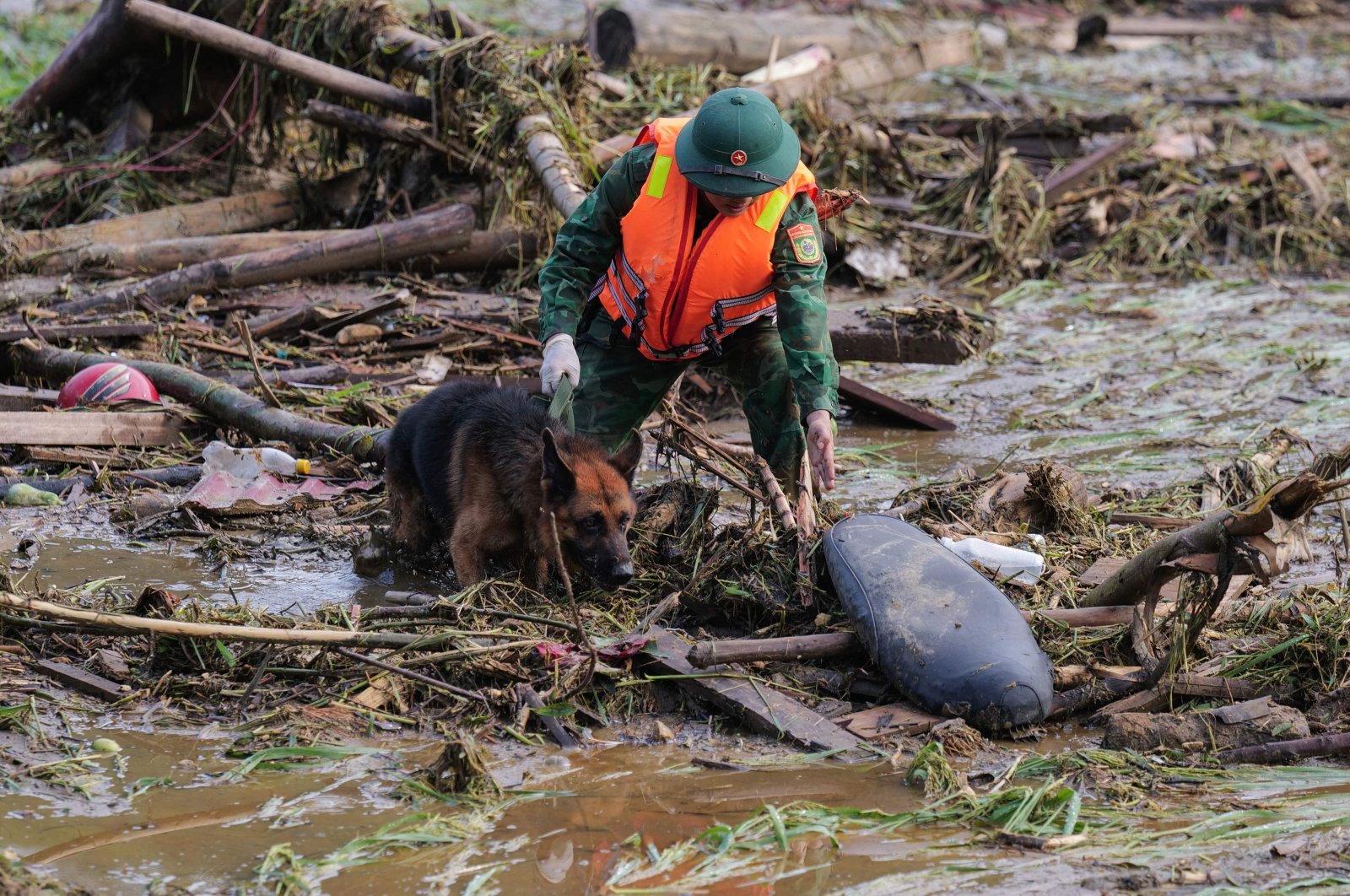 A rescue official works with a dog as they sift through debris at the site of a landslide in Lang Nu, in Lao Cai province, Vietnam, Sept. 12, 2024. (AFP Photo)