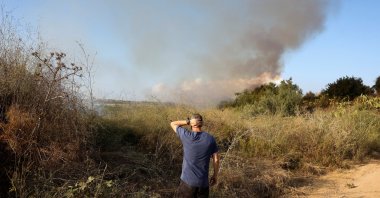 A man looks as smoke billows after a missile attack from Yemen in central Israel, Sept. 15, 2024. (Reuters Photo)