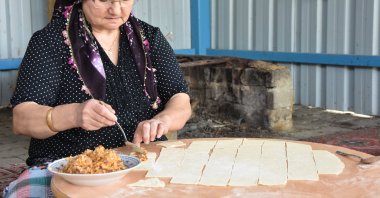 A woman makes "sini mantısı" in the traditional way in Tekirdağ, Türkiye, Sept. 15, 2024. (AA Photo)