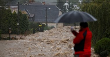 A man stands with an umbrella near a flood-affected area, following heavy rainfall in Lipova Lazne, Czech Republic, September 15, 2024. REUTERS/David W Cerny