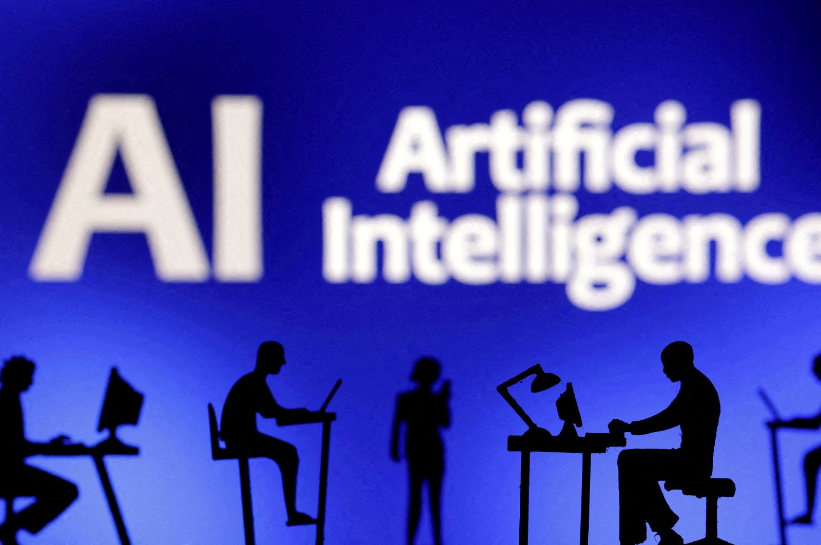 Figurines with computers and smartphones are seen in front of the words &quot;Artificial Intelligence AI&quot; in this illustration taken on Feb. 19, 2024. (Reuters Photo)