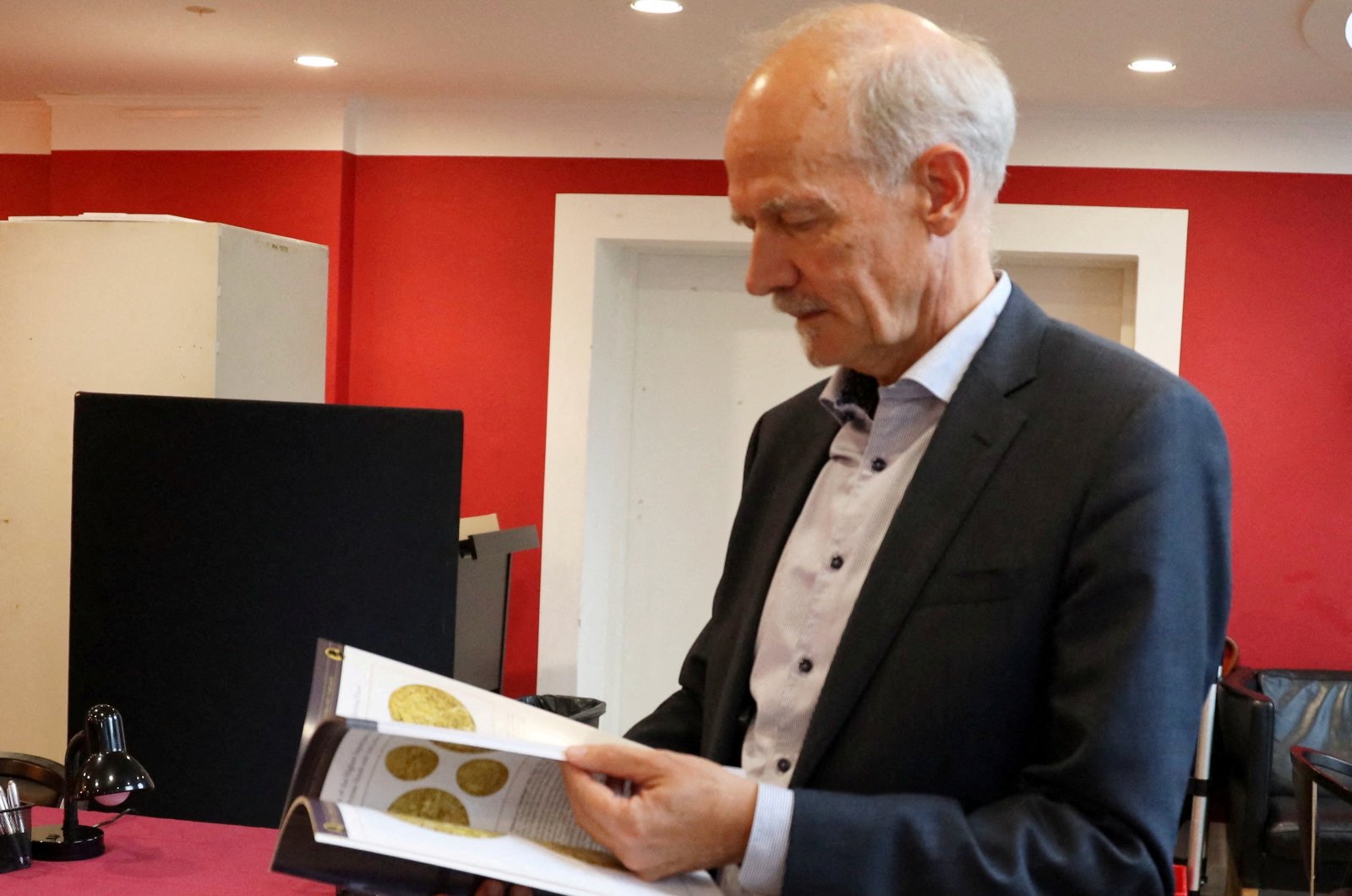 Michael Fornitz, professional numismatist and director of Stack&#039;s Bowers auction house, looks at the catalog for the first lot of coins from the coin collection of Danish butter magnate Lars Emil Bruun, Copenhagen, Denmark, Sept. 11, 2024. (Reuters Photo)