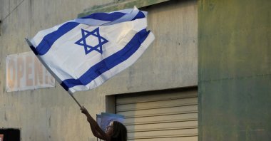 A girl waves an Israeli flag during a support rally outside the Jewish central Synagogue in the coastal town of Larnaca, Greek Cyprus, Oct. 17, 2023. (AP Photo)
