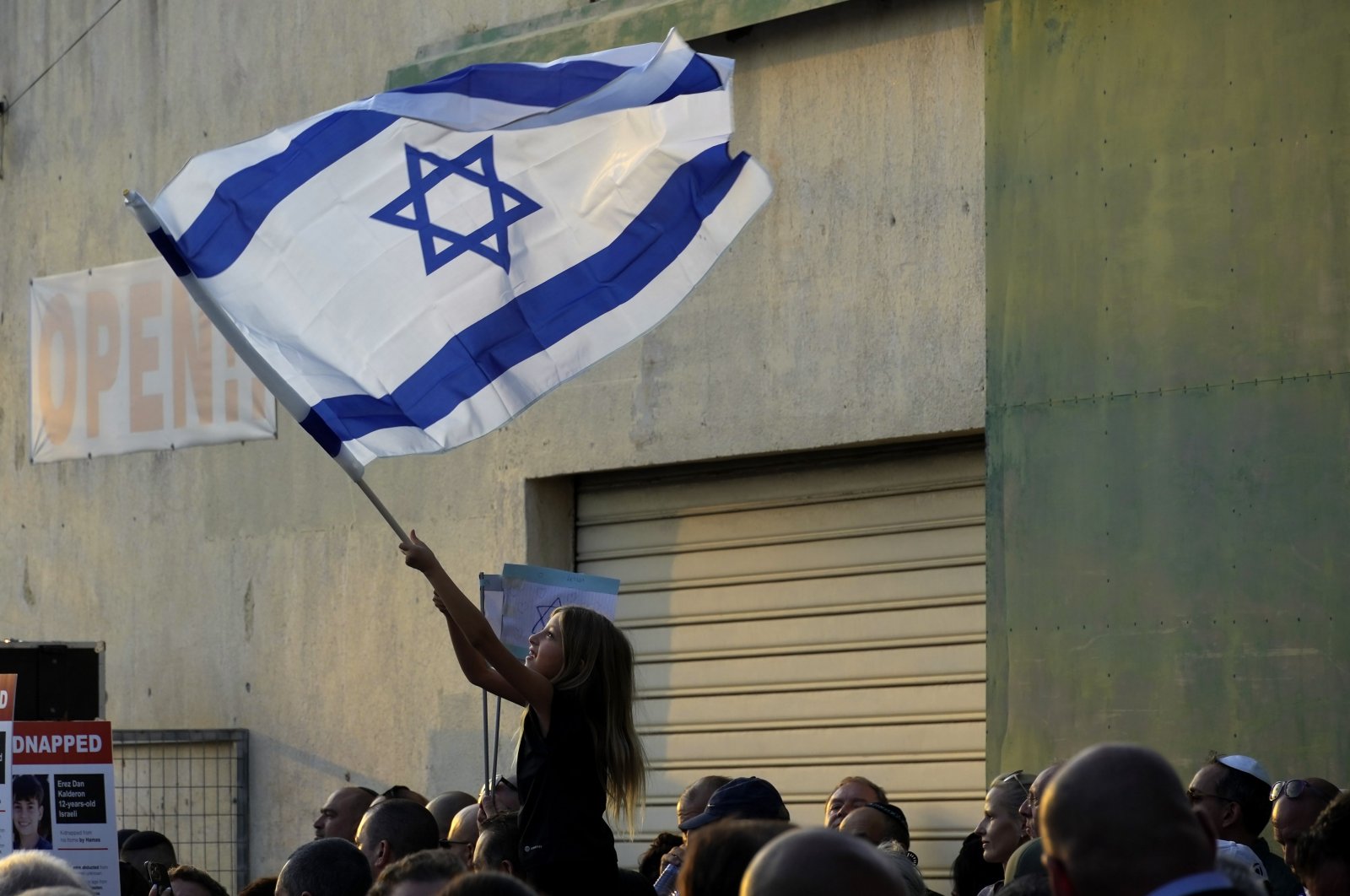 A girl waves an Israeli flag during a support rally outside the Jewish central Synagogue in the coastal town of Larnaca, Greek Cyprus, Oct. 17, 2023. (AP Photo)