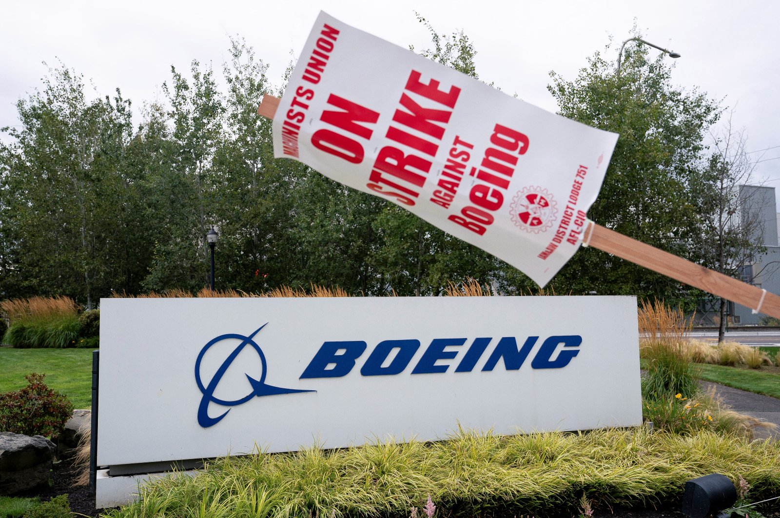 A strike sign hangs from a post near a Boeing sign as Boeing factory workers and supporters gather on a picket line during the third day of a strike near the entrance to a Boeing production facility in Renton, Washington, U.S., Sept. 15, 2024. (Reuters Photo)