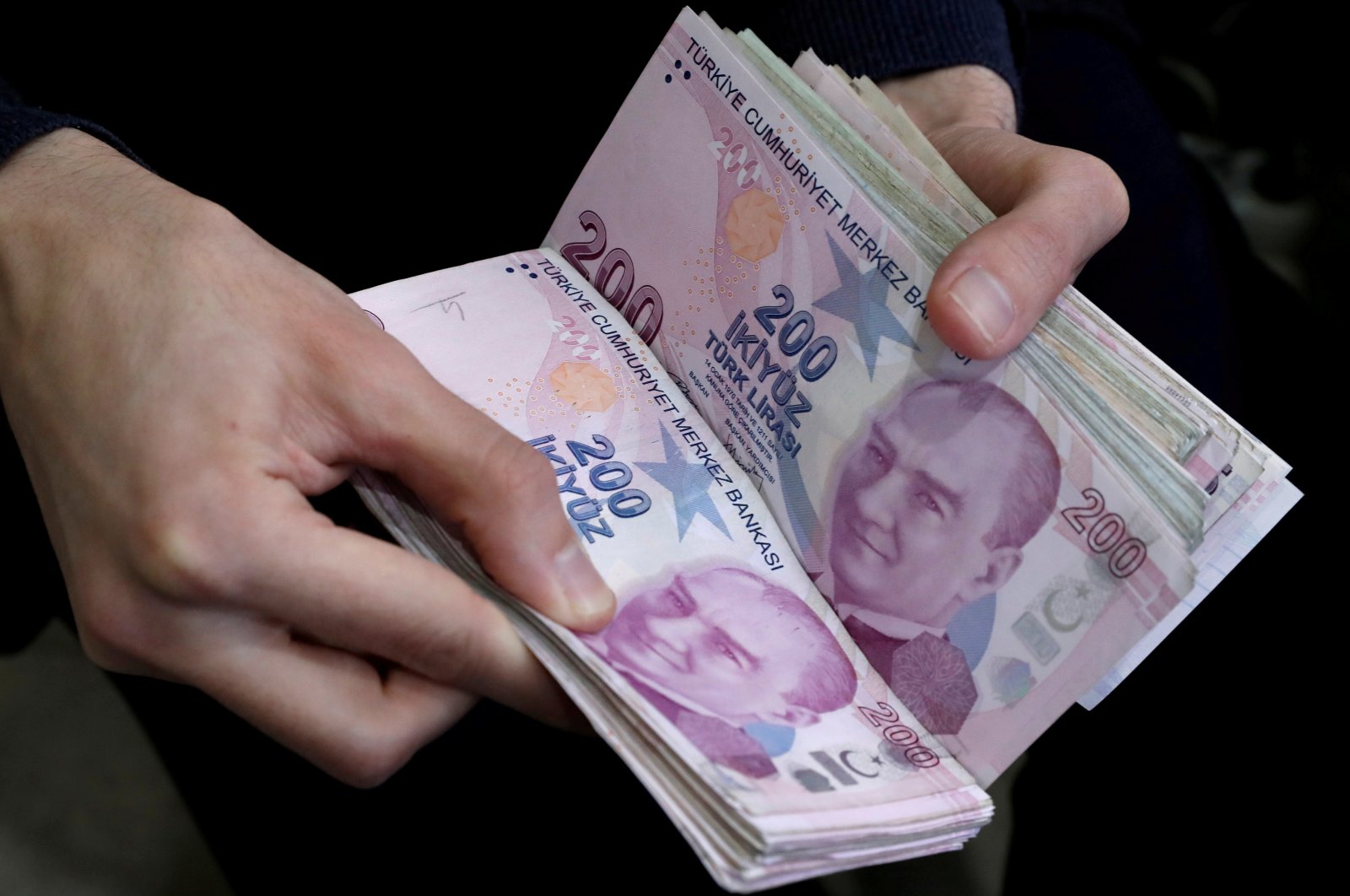 A merchant counts Turkish lira banknotes at the Grand Bazaar in Istanbul, Türkiye, March 29, 2019. (Reuters Photo)