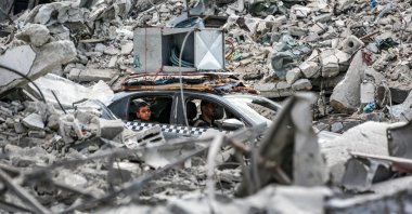 A vehicle moves past the rubble of collapsed buildings in Khan Younis in the southern Gaza Strip, Palestine, Sept. 16, 2024. (AFP Photo)