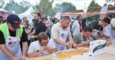 Participants race in the börek-eating competition, Bursa, Türkiye, Sept 16, 2024. (IHA Photo)