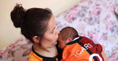 Zehra Ay poses for a photo holding baby Umut Halil Icardi, Mersin, Türkiye, Sept. 11, 2024. (AA Photo)