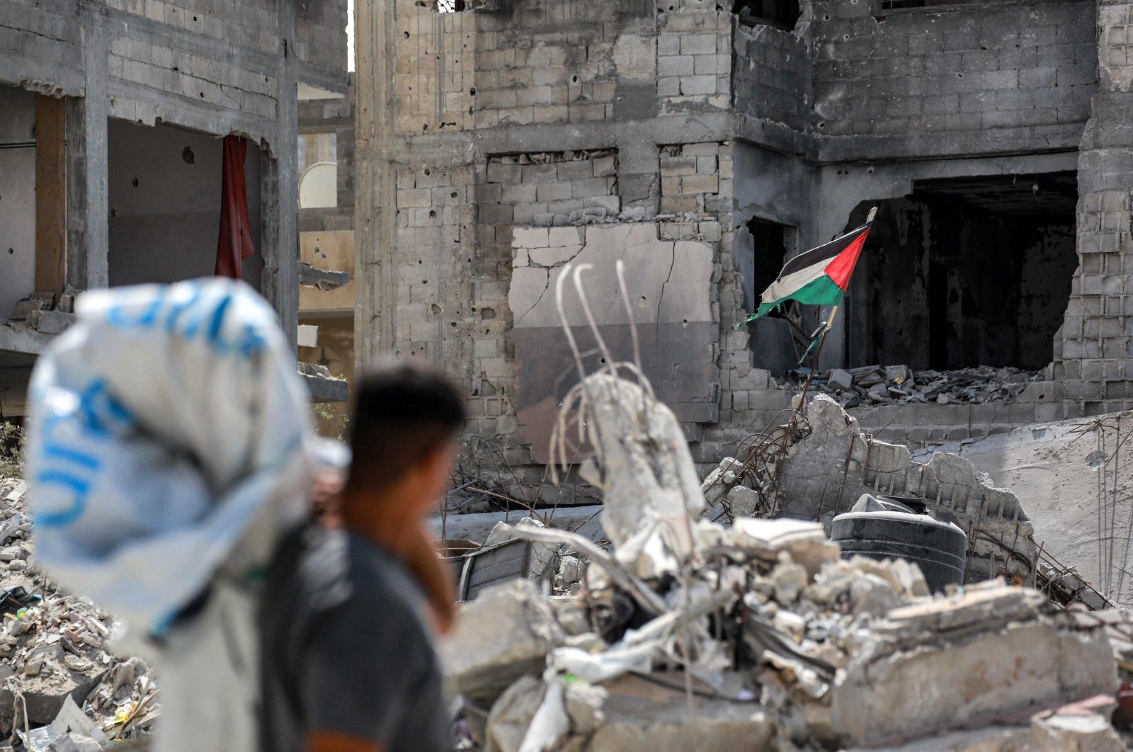 A man views a tattered Palestinian flag flying in a ruined building in Khan Younis in the southern Gaza Strip, Palestine, Sept. 16, 2024. (AFP Photo)