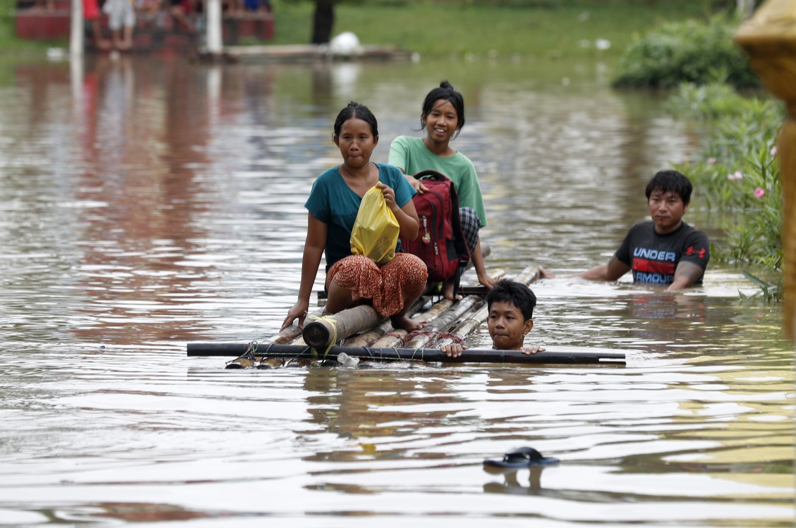 Flood victims wade through the flood waters with a makeshift raft during the flood in Taungoo, Bago division, Myanmar, Sept. 14, 2024. (EPA Photo)