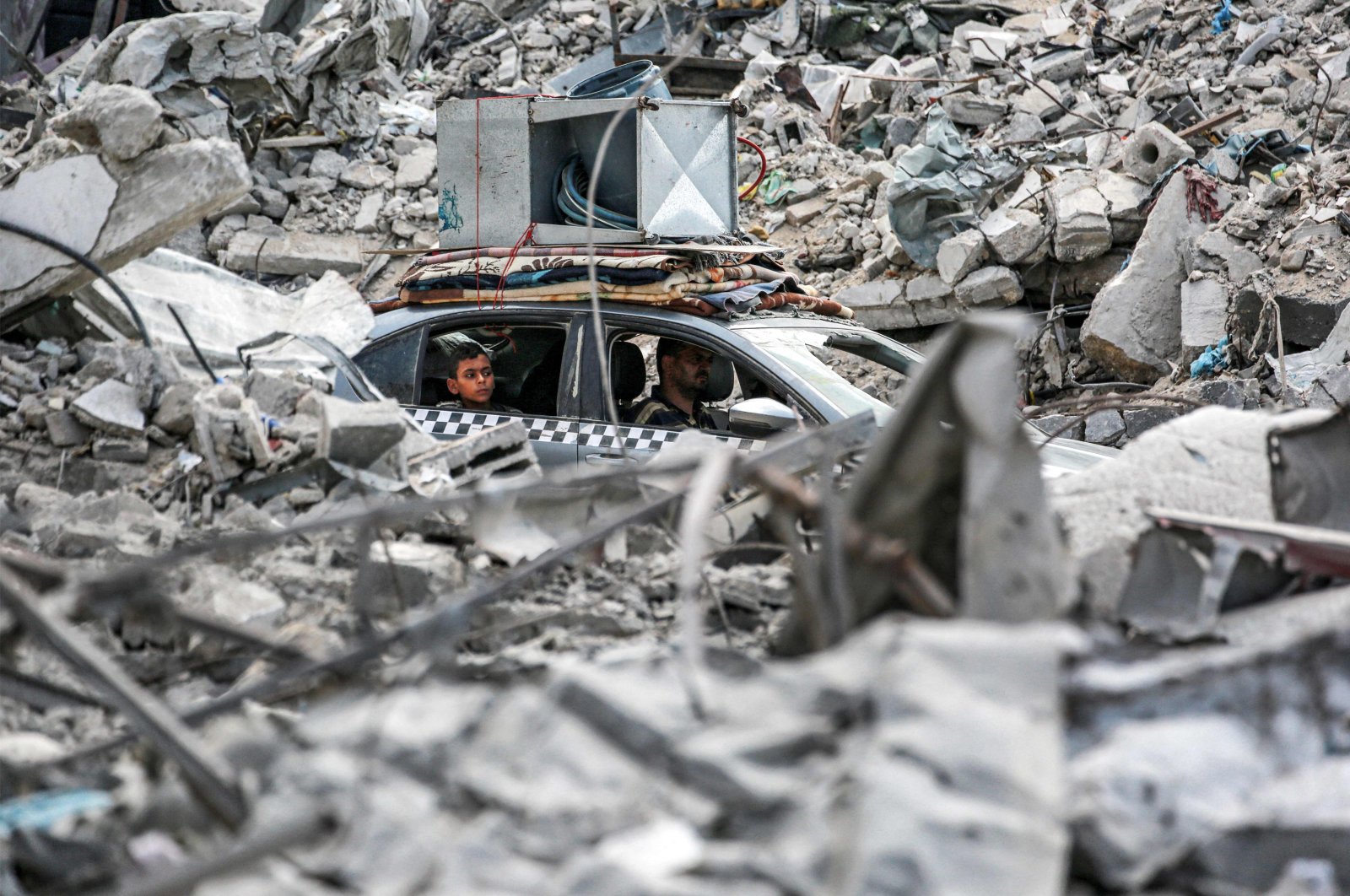 A vehicle moves past the rubble of collapsed buildings in Khan Younis in the southern Gaza Strip, Palestine, Sept. 16, 2024. (AFP Photo)