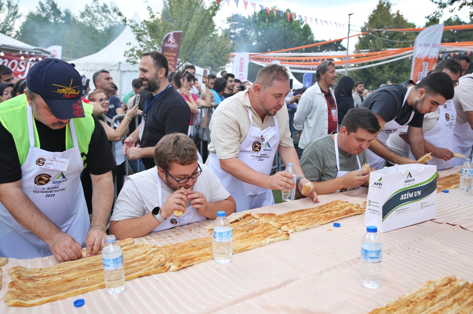 Participants race in the börek-eating competition, Bursa, Türkiye, Sept 16, 2024. (IHA Photo)