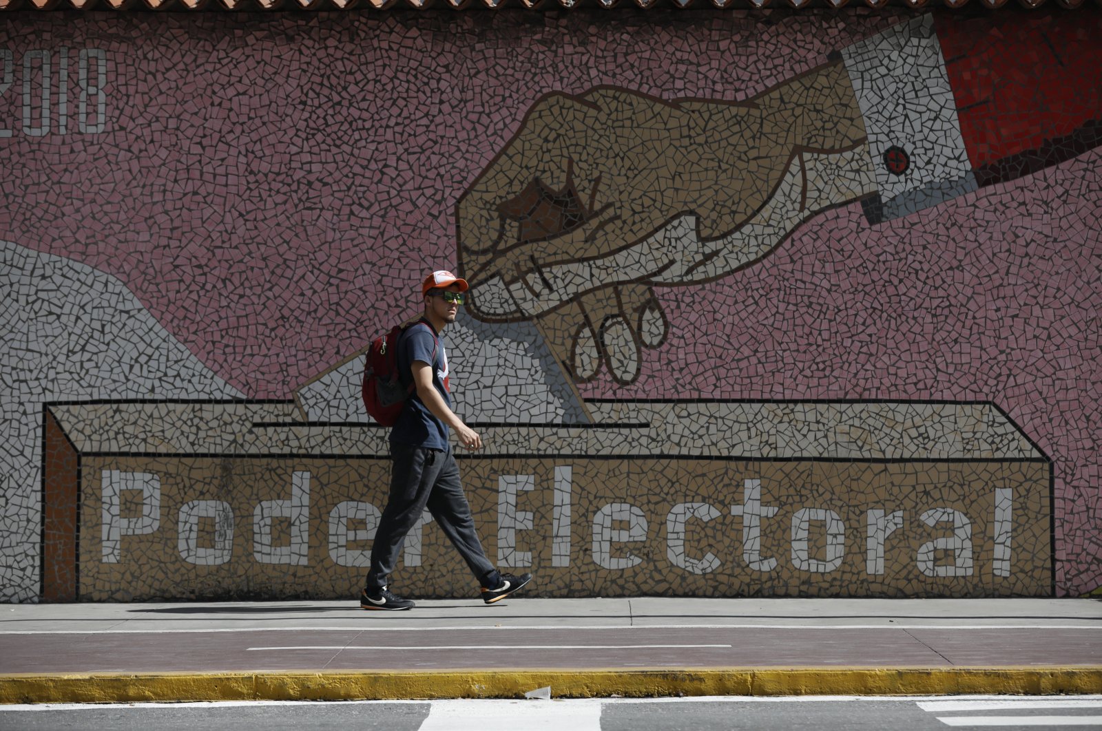 A man walks by a mural depicting a ballot box in Caracas, Venezuela, July 31, 2024. (AP Photo)