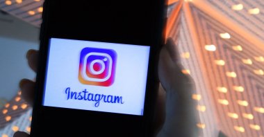 A person looks at a smartphone with an Instagram logo displayed on the screen in Arlington, Virginia, U.S., Aug. 17, 2021. (AFP Photo)