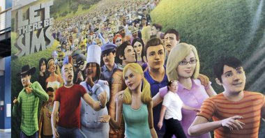 An employee passes a poster for "The Sims 3" video game in the cafeteria of the Electronic Arts Inc. headquarters in Redwood City, California, U.S., July 20, 2010. (Getty Images)