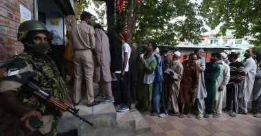 An Indian paramilitary soldier stands guard as voters wait in a queue for local assembly elections, at Naira, southern Kashmir, Sept. 18, 2024. (EPA Photo)