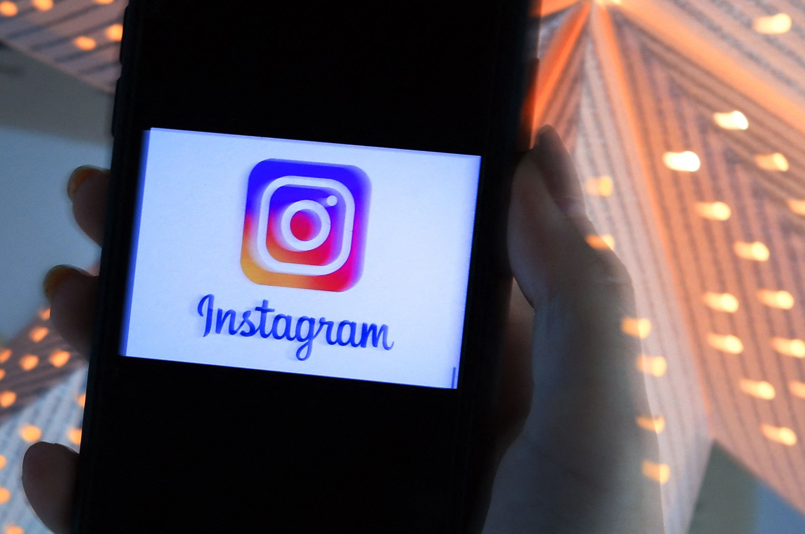 A person looks at a smartphone with an Instagram logo displayed on the screen in Arlington, Virginia, U.S., Aug. 17, 2021. (AFP Photo)