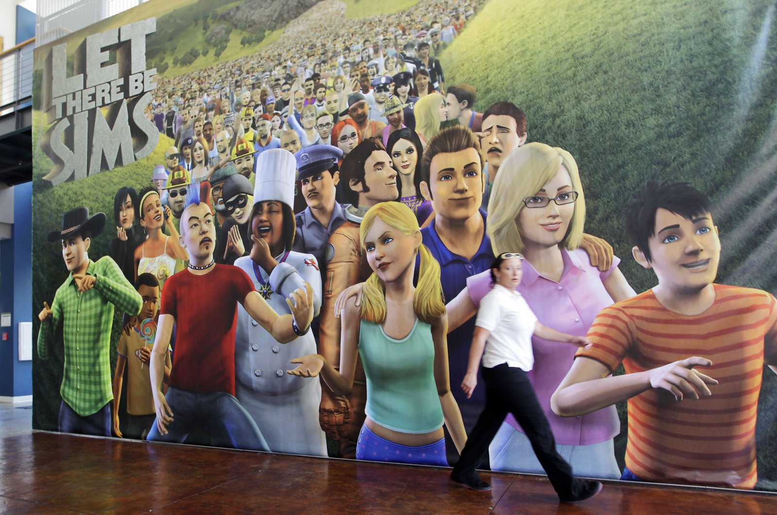 An employee passes a poster for &quot;The Sims 3&quot; video game in the cafeteria of the Electronic Arts Inc. headquarters in Redwood City, California, U.S., July 20, 2010. (Getty Images)