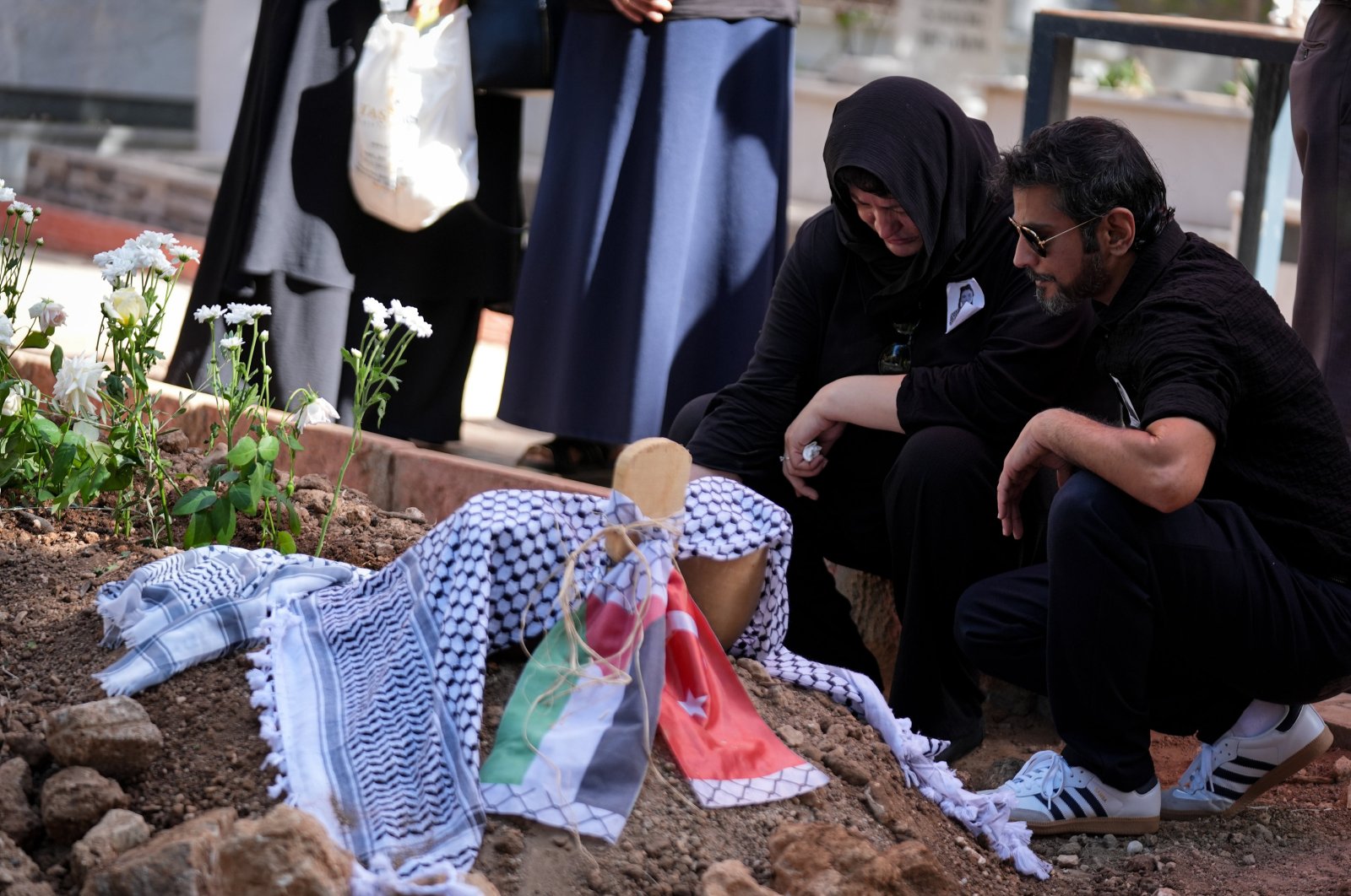 Rabia Birden (2nd R), mother of Ayşenur Ezgi Eygi, weeps by her grave in Didim, Aydın, western Türkiye, Sept. 14, 2024. (AA Photo)