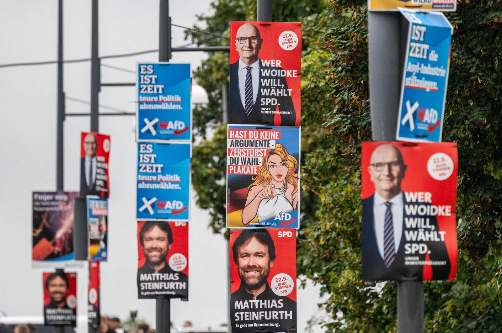 Election campaign placards for the Social Democratic Party (SPD) and far-right Alternative for Germany (AfD) parties hang on lamp posts, Frankfurt, Germany, Sept. 16, 2024. (AFP Photo)