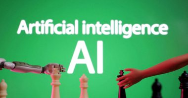 Words reading &quot;Artificial intelligence AI,&quot; a miniature of a robot and toy hand are pictured in this illustration from Dec. 14, 2023. (Reuters Photo)