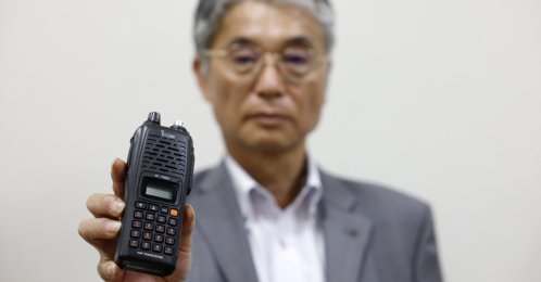 Japanese walkie-talkie maker Icom Inc. Director Yoshiki Enomoto shows its radio model IC-V82 at the company head office in Osaka, Japan, Sept. 19, 2024. (EPA Photo)