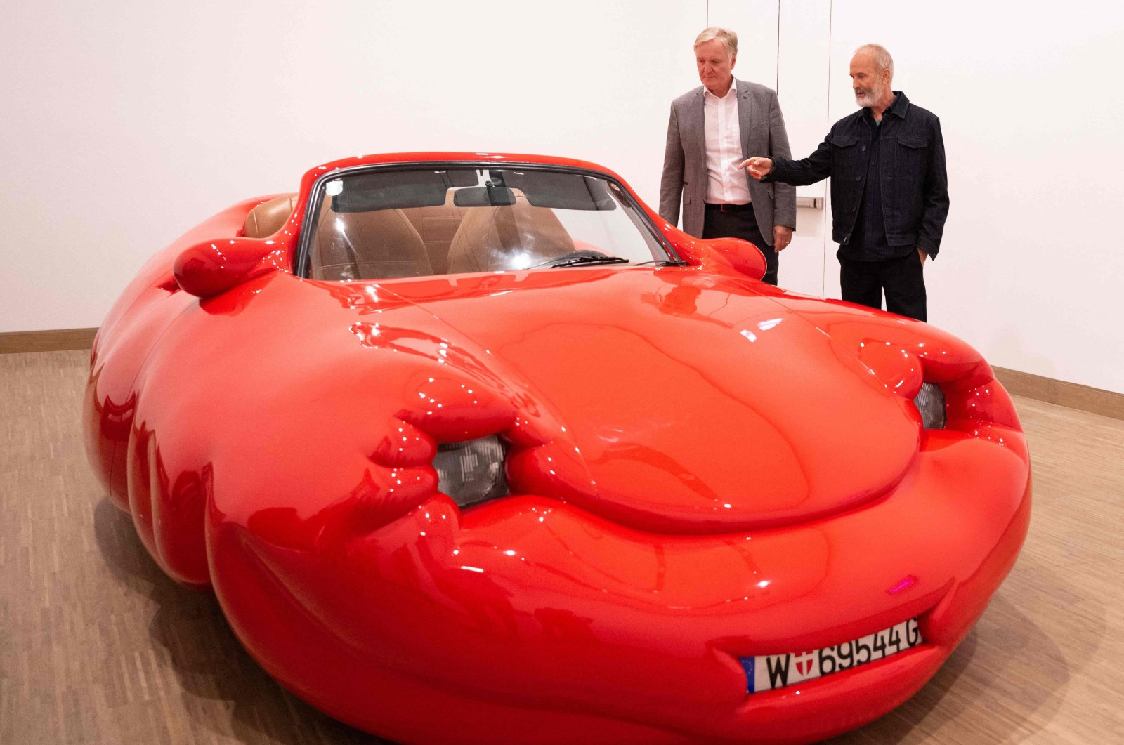 General director of Albertina Klaus Albrecht Schroeder (L) and Austrian artist Erwin Wurm react next to his work &quot;Fat Convertible,&quot; Vienna, Austria, Sept. 12, 2024. (AFP Photo)