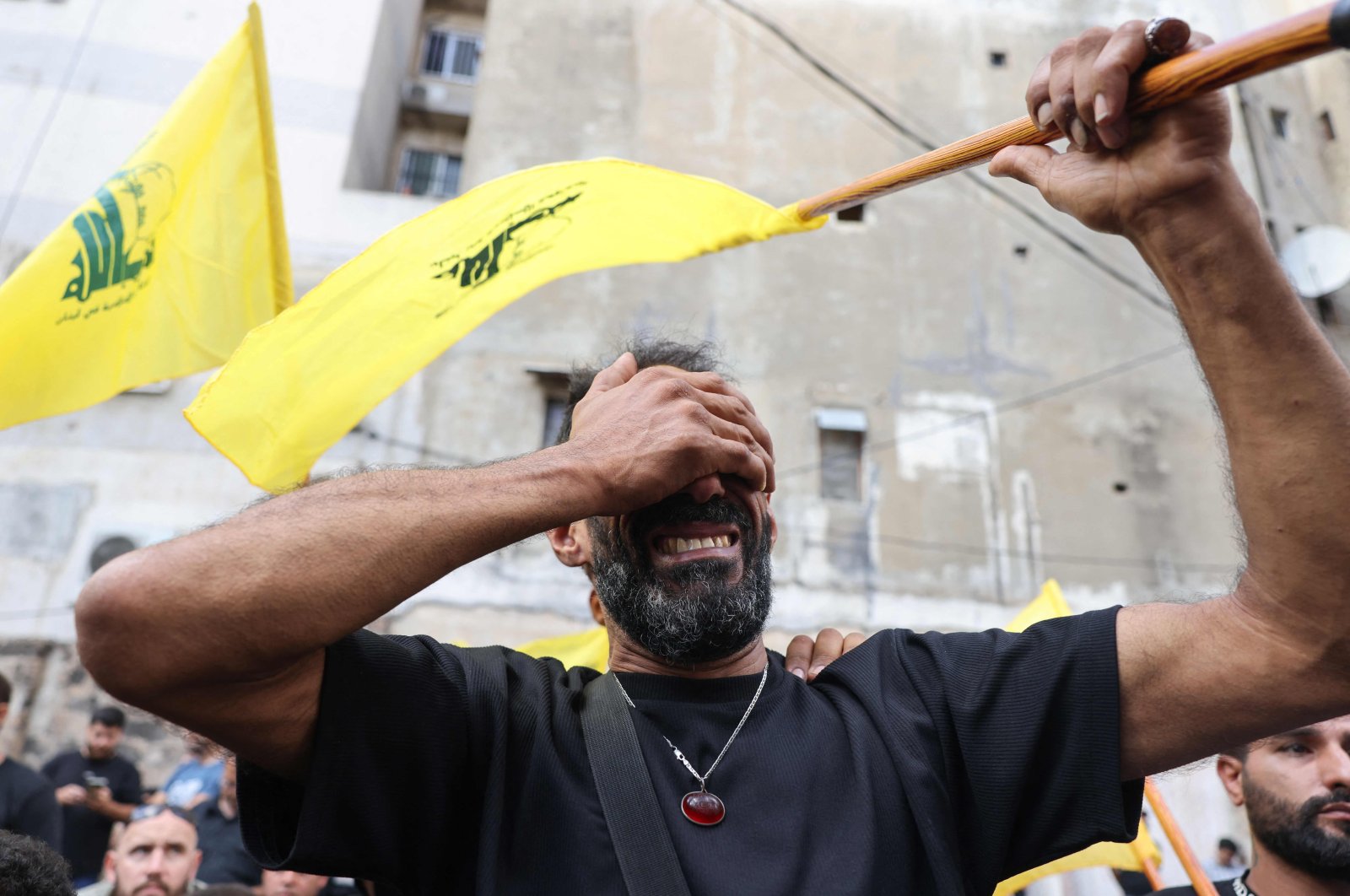 A man reacts while holding a Hezbollah flag during the funeral of people killed after hundreds of paging devices exploded across Lebanon, Sept. 18, 2024. (AFP Photo)