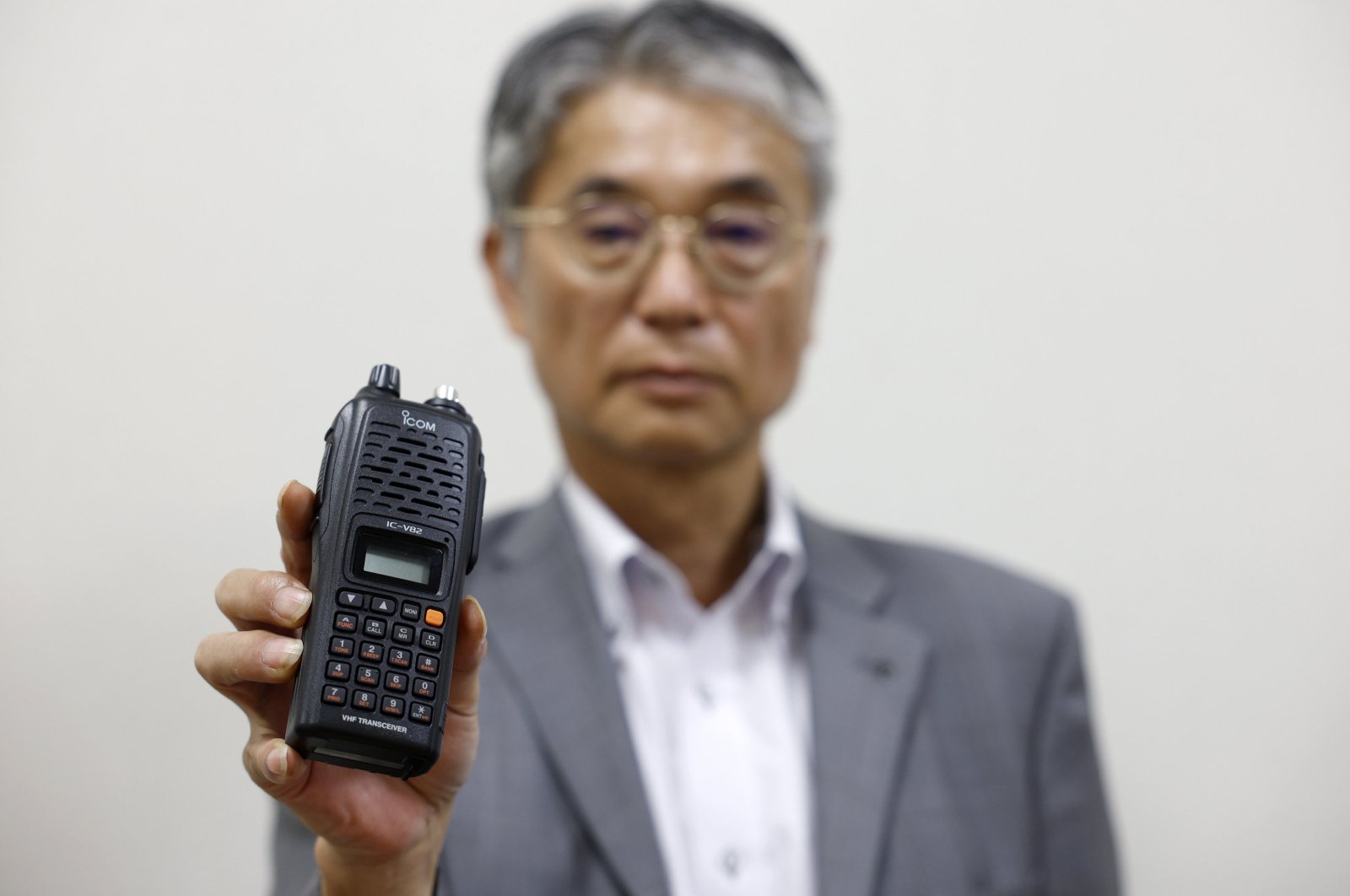 Japanese walkie-talkie maker Icom Inc. Director Yoshiki Enomoto shows its radio model IC-V82 at the company head office in Osaka, Japan, Sept. 19, 2024. (EPA Photo)