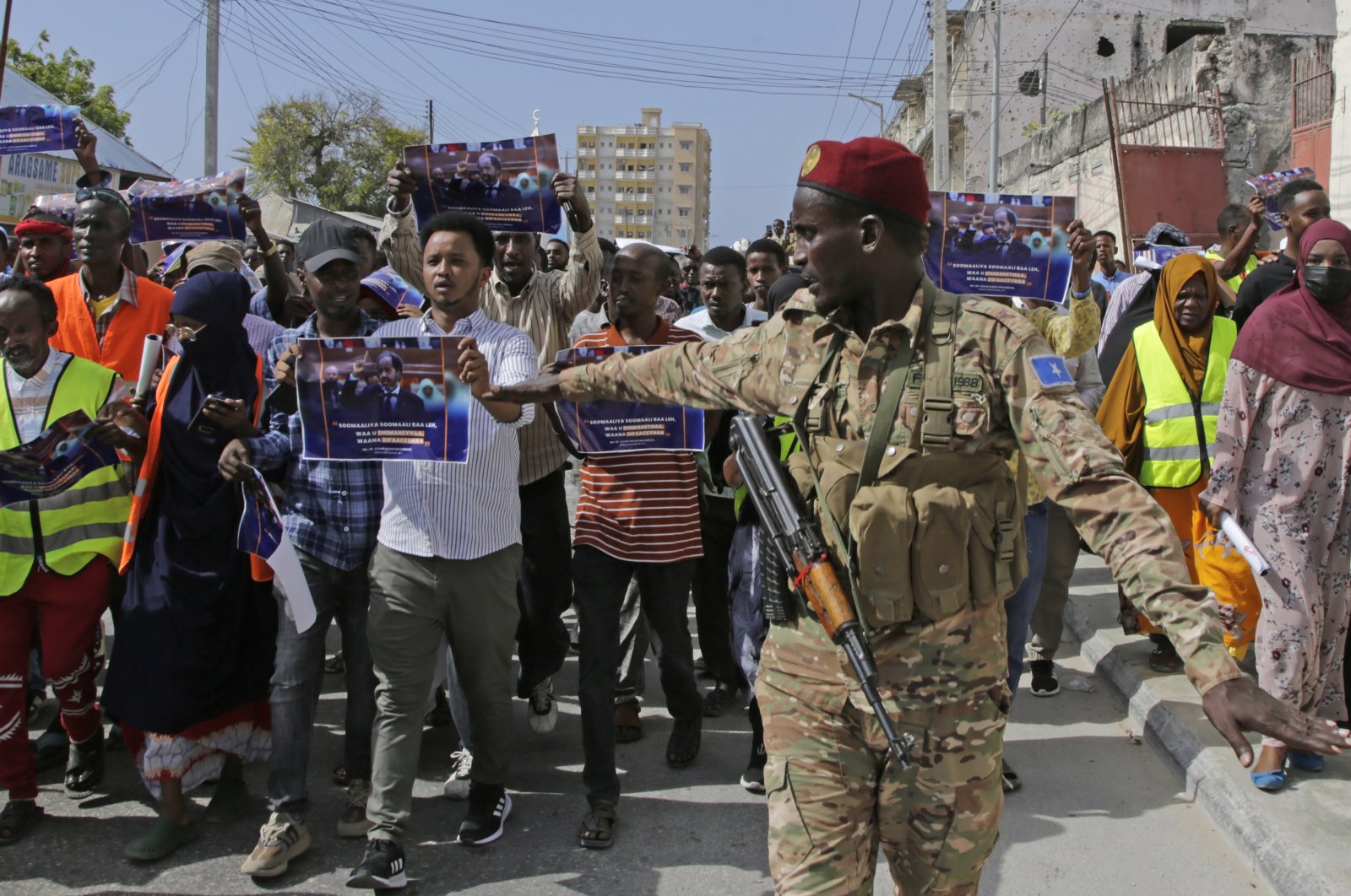 A Somali soldier controls the crowd as thousands of people protest an agreement signed between Ethiopia and the breakaway region of Somaliland in Mogadishu, Somalia, Jan.3, 2024. (AP Photo)