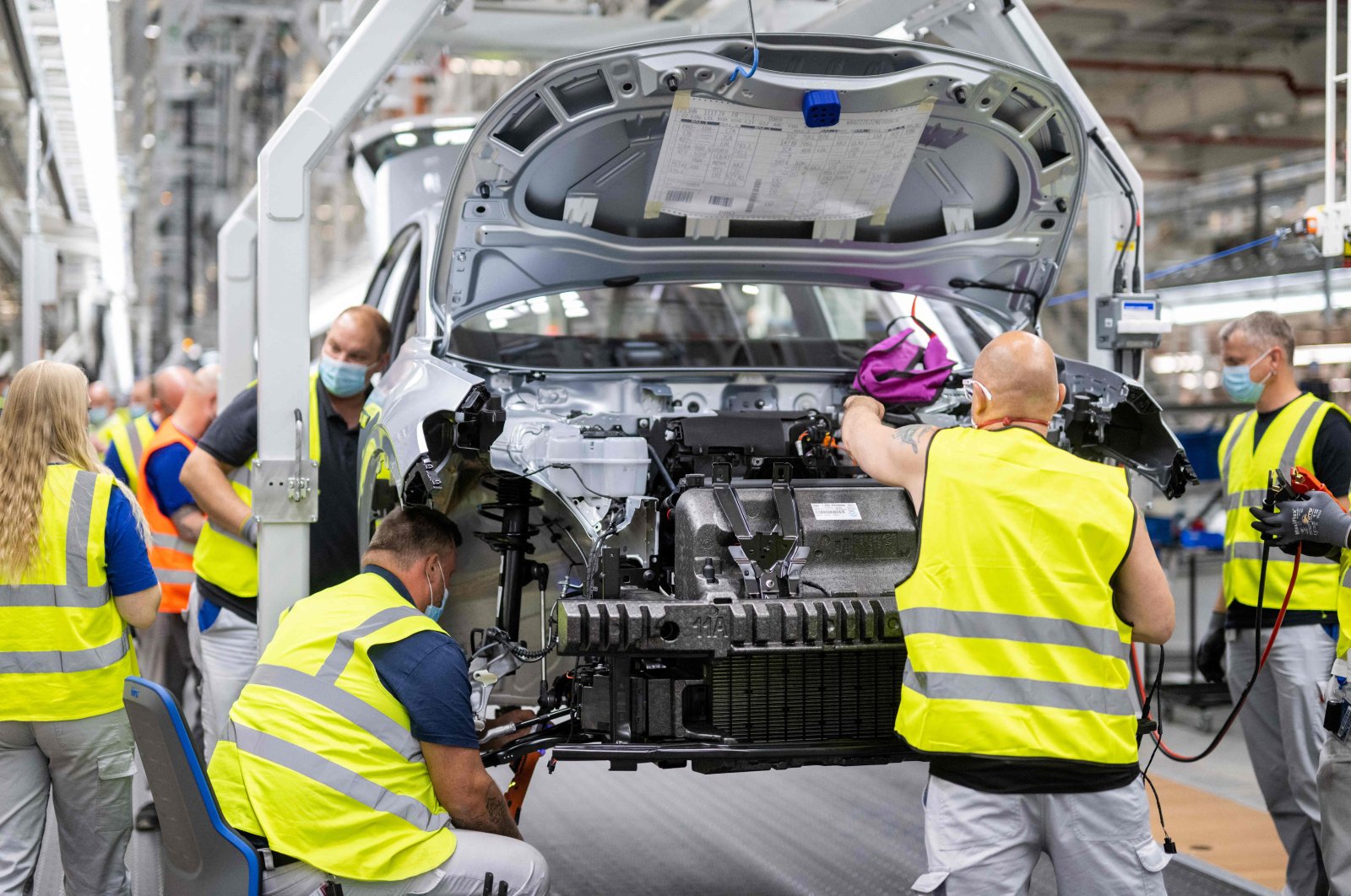 Employees work at the assembly line of the Volkswagen (VW) ID 4 electric car of German carmaker Volkswagen, in the production site of Emden, northern Germany, May 20, 2022. (AFP File Photo)