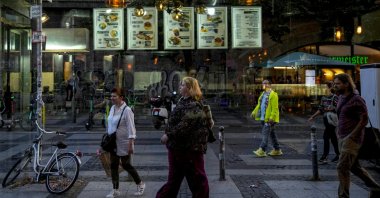 People are seen through the window of a döner kebab restaurant in Berlin, Germany, Sept. 18, 2024. (AP Photo)