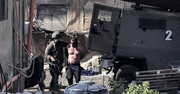 Israeli army soldiers detain a topless blindfolded man during an army raid in Qabatiyah south of Jenin in the occupied West Bank, Palestine, Sept. 19, 2024. (AFP Photo)