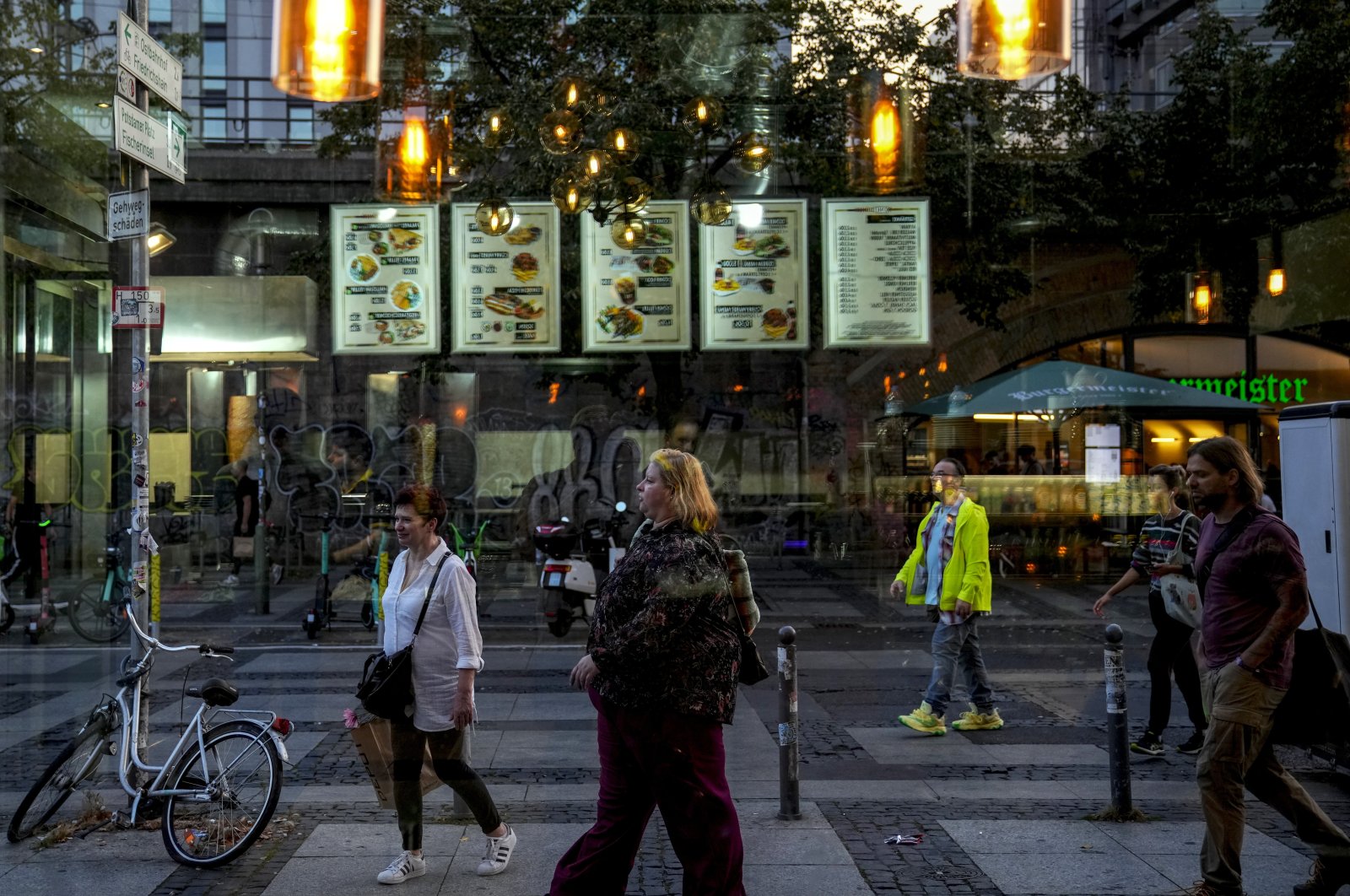 People are seen through the window of a döner kebab restaurant in Berlin, Germany, Sept. 18, 2024. (AP Photo)